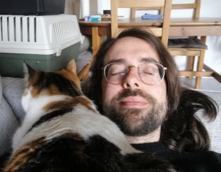 Katze liegt auf Katzensitter - Katzensitter glücklich Erneut liegt Shiro auf dem Katzensitter, diesmal auf seiner Brust. Auch zu sehen: Des Katzensitters Gesicht mit geschlossenen Augen und einem leichten Lächeln.