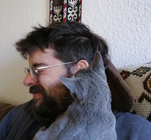 2023 hat mir dieser Kater des öfteren ein Ohr abgekauft, wort-wörtlich... Ein kleines Katerjunges knabbert dem Katzensitter am Ohr. Dieser wendet den Kopf ab und muss sich das lachen verkneifen. Kitzelt tut es auch, hab ich gehört...